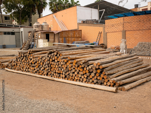Obraz na płótnie Stacked Logs Showing Bark with a Brick Wall Backdrop w salonie