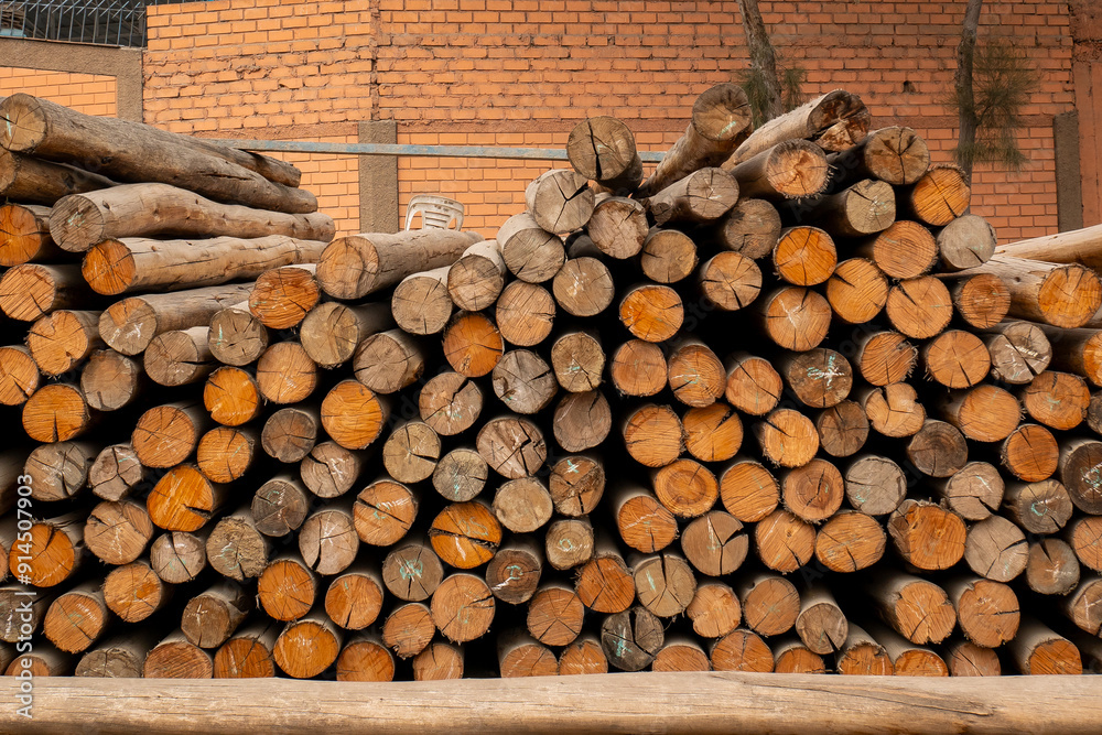 Stacked Logs Showing Bark with a Brick Wall Backdrop