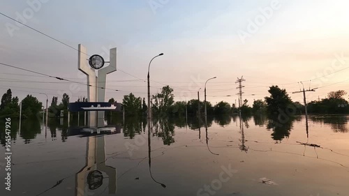 Flooded streets in Kherson town with beautiful sunset at background. Explosion of dam on Dnipro river in city of Novaya Kakhovka. Consequences of detonation of Kakhovka Hydroelectric Power Station photo