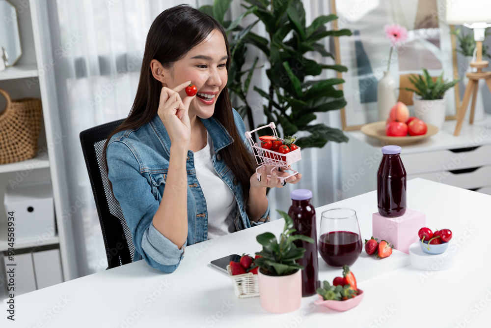 Smiling young beautiful Asian reviewing tasty mixed strawberry and cherry juice detox drinks, showing healthy product to promote for special promotion selling on social media online record. Stratagem. Smiling young beautiful Asian reviewing tasty mixed strawberry and cherry juice detox drinks, showing healthy product to promote for special promotion selling on social media online record. Stratagem.