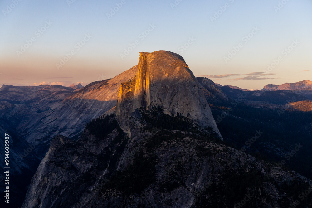 Fototapeta premium Experience the breathtaking beauty of Yosemite National Park at sunset behind Half Dome, where golden hues illuminate natures masterpiece, creating an unforgettable sense of tranquility and wonder