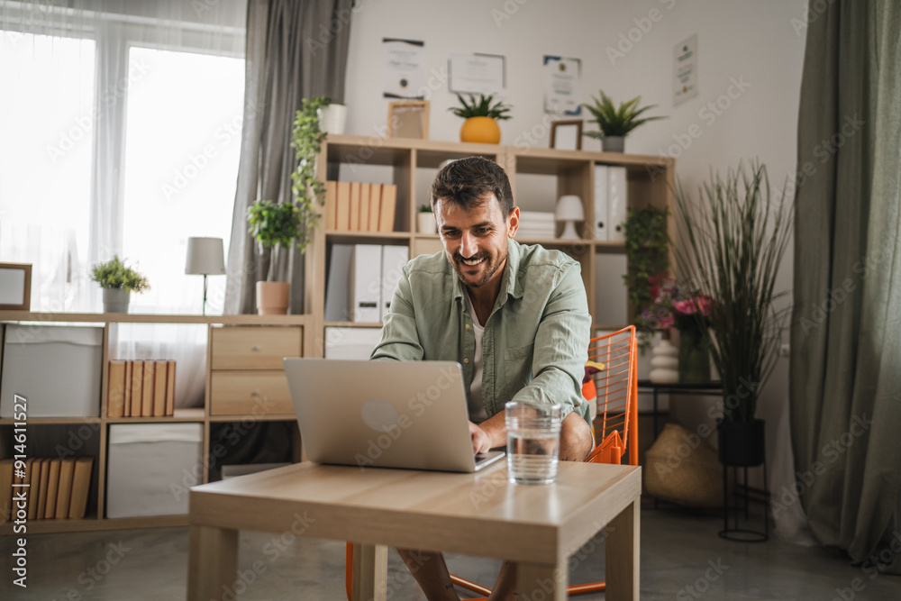 Adult caucasian man sit, smile and use laptop for work or fun at home Adult caucasian man sit, smile and use laptop for work or fun at home