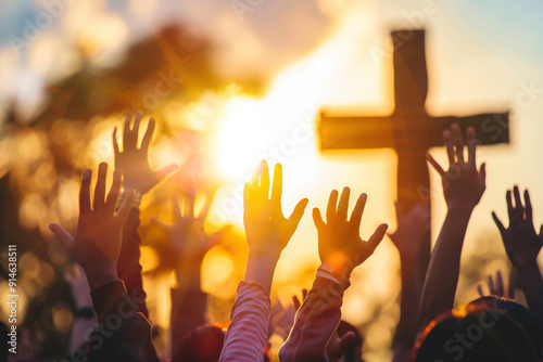 Spiritual devotion ceremony at church congregation for religious gathering. Religion concept. People raising hands in worship during a sunset sunrise with a cross in the background.