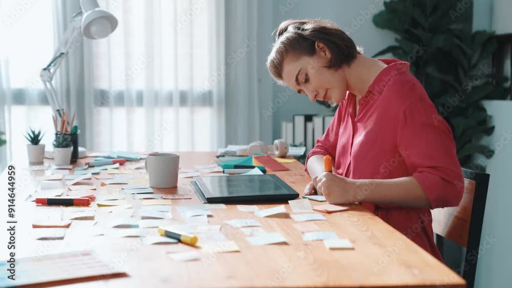 Top view of designer writing idea on colorful sticky notes while sitting at meeting table with tablet display logo design. Professional business woman looking design and making a decision. Symposium. Top view of designer writing idea on colorful sticky notes while sitting at meeting table with tablet display logo design. Professional business woman looking design and making a decision. Symposium.