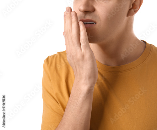 Handsome young man feeling bad smell from mouth on white background, closeup photo