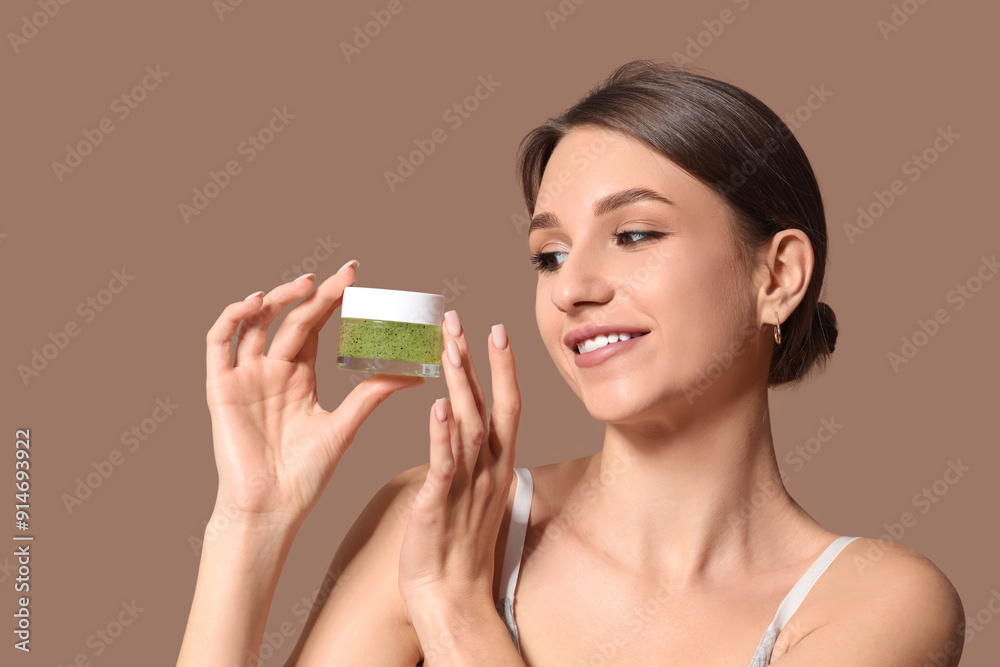 Beautiful young woman with jar of cosmetic cream on brown background Beautiful young woman with jar of cosmetic cream on brown background