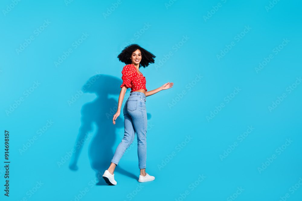 Full size rear profile photo of pretty young woman walk empty space wear top isolated on blue color background Full size rear profile photo of pretty young woman walk empty space wear top isolated on blue color background