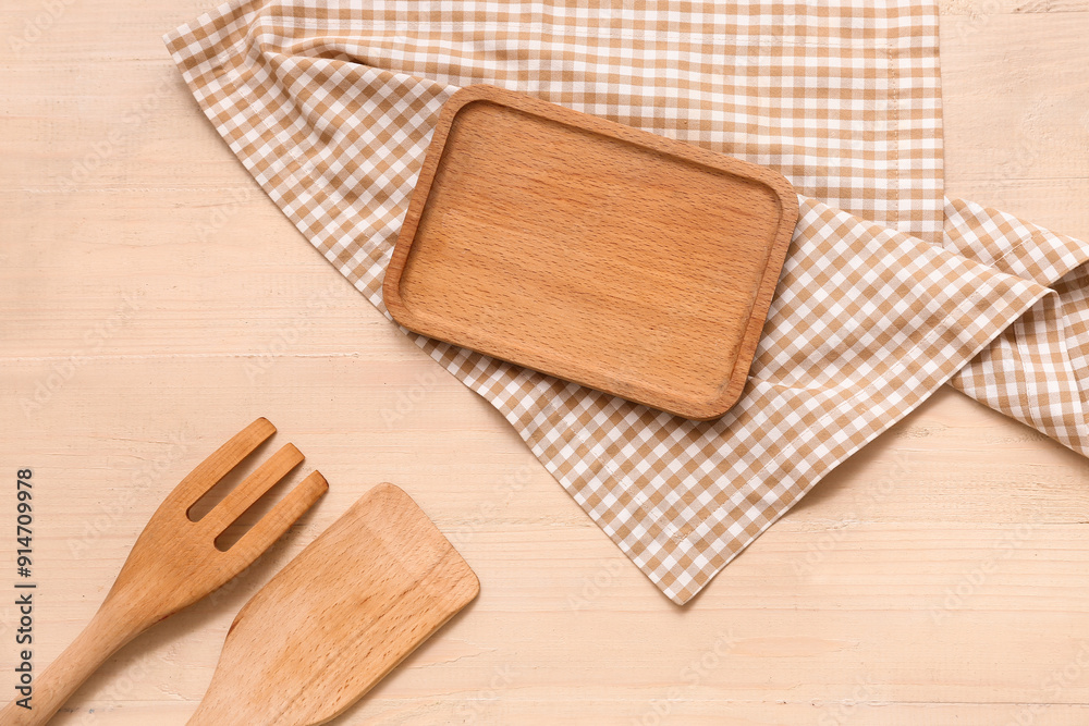 Napkin with fork, spatula and board on wooden background Napkin with fork, spatula and board on wooden background