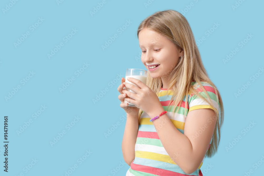 Little girl with glass of milk on blue background Little girl with glass of milk on blue background