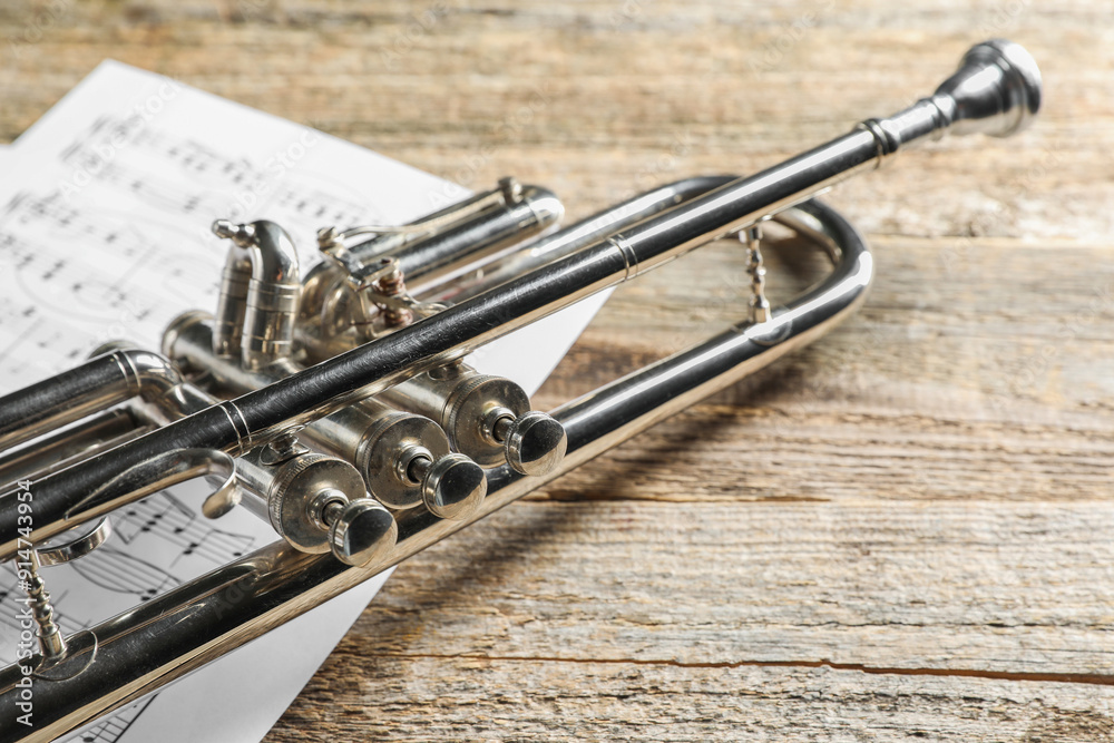 Trumpet and music sheets on wooden table, closeup Trumpet and music sheets on wooden table, closeup