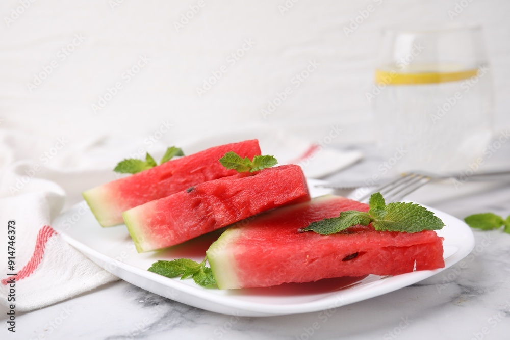 Fresh watermelon slices with mint leaves on white marble table, closeup Fresh watermelon slices with mint leaves on white marble table, closeup