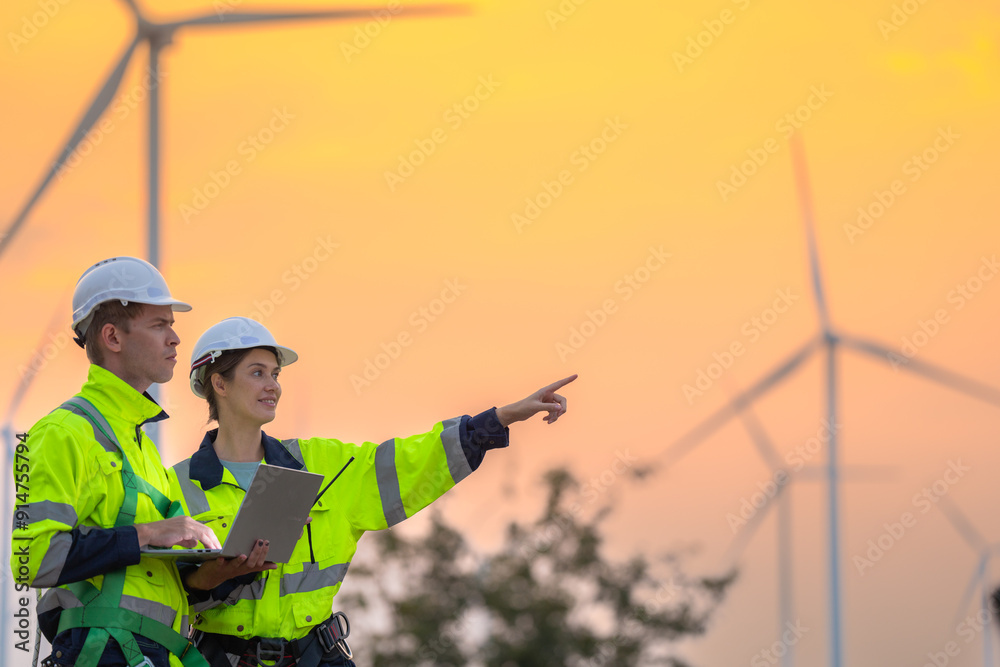 Team Engineers men and woman checking and inspecting on construction with sunset sky. people operation. Wind turbine for electrical of clean energy and environment. Industrial of sustainable. Team Engineers men and woman checking and inspecting on construction with sunset sky. people operation. Wind turbine for electrical of clean energy and environment. Industrial of sustainable.