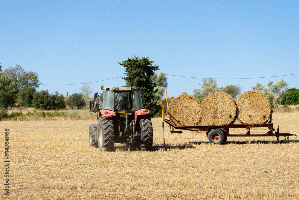 A tractor picks up the wheat field A tractor picks up the wheat field