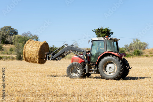 A tractor picks up the wheat field photo