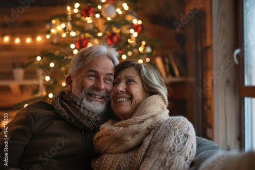 Happy elderly couple, filled with love, shares a heartfelt warm embrace in a stunningly decorated cozy home. Merry Christmas, Happy New Year