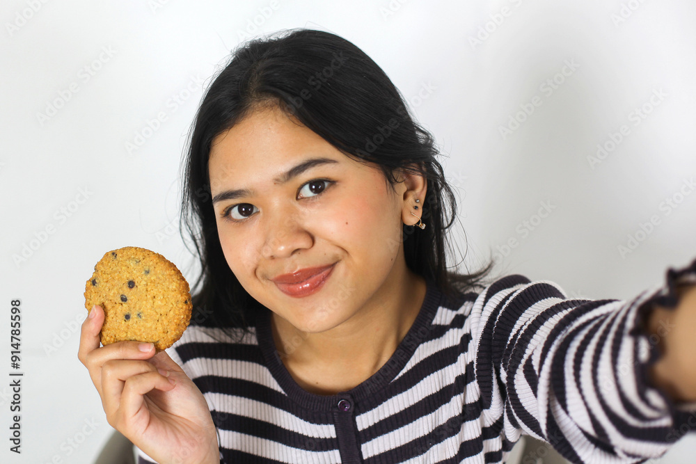 Cheerful Young Asian Female Selfie While Showing Cookies Topped With Chocolate Chips Cheerful Young Asian Female Selfie While Showing Cookies Topped With Chocolate Chips