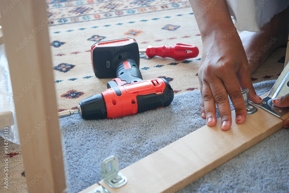 Expertly assembling furniture with power tools while surrounded by a cozy, inviting setting Expertly assembling furniture with power tools while surrounded by a cozy, inviting setting