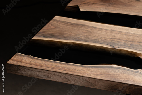 Expensive vintage furniture. The table is covered with epoxy resin and varnished. Luxury quality wood processing. Wooden table on a dark background. Black river made of epoxy resin. photo