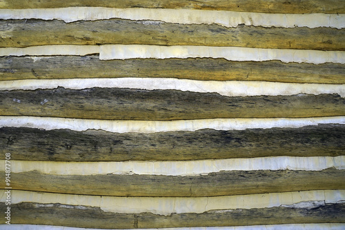 Detailed view of the wood and old cement forming one wall of a log cabin dating from the early 20th century