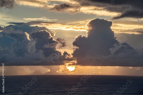 Dramatic sky with low sun behind clouds above the ocean