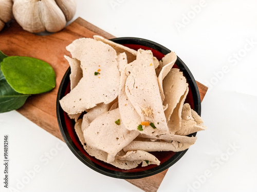 White Basreng with thinly slice like chips made from fried bakso. A typical Sundanese, West Java ,Indonesian non spicy crispy snack. In isolated white background.
 photo