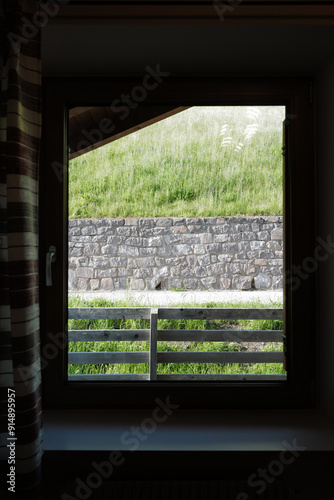 View from bedroom window frame of natural landscape of green hill range