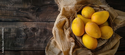 Yellow Mangoes in a Basket on Wooden Background