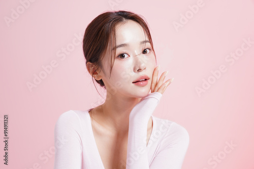 ピンク背景で撮影をした若い女性のキャッチーなビューティー ポートレート