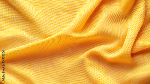 Yellow textured fabric draped gracefully on a surface, showcasing its intricate weave and color