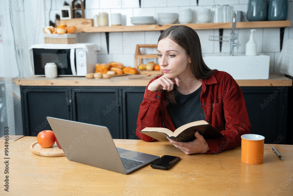 Woman uses laptop to work in the kitchen Woman uses laptop to work in the kitchen