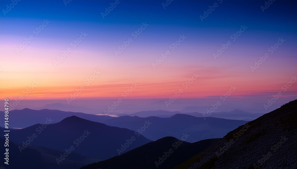 Scenic mountain landscape during twilight with a colorful sky transitioning from blue to shades of pink and orange