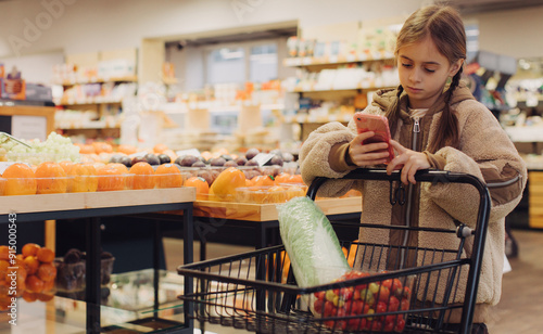 Cheerful teen girl shopping for organic fruits without plastic bags in local food store. Vegan zero waste girl choosing fresh fruits and vegetables in supermarket. Part of a series photo