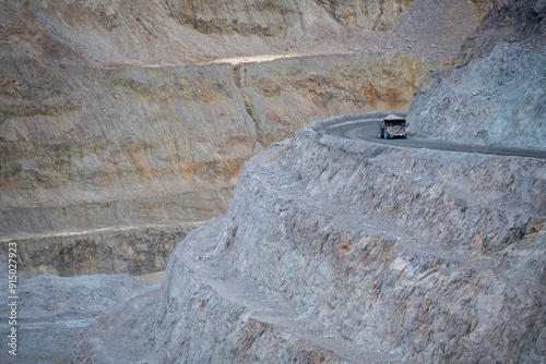 Heavy duty haul truck full of rock driving on an open pit mine r