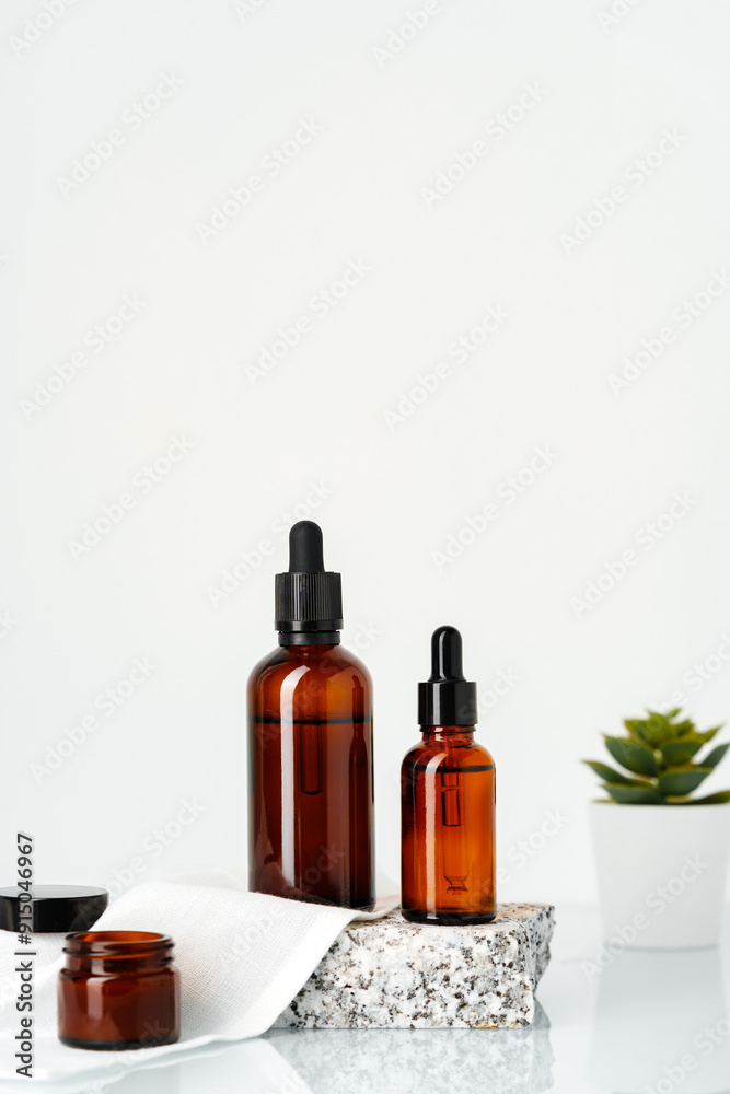 Amber Glass Bottles With Dropper Tops Displayed on a Stone Platform Amber Glass Bottles With Dropper Tops Displayed on a Stone Platform