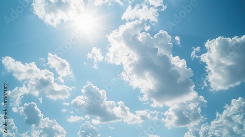 A clear blue sky with bright sunshine peeking through white clouds