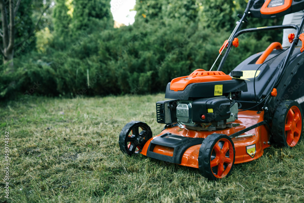 Obraz premium The gardener is tending the garden, the lawn mower is cutting the grass