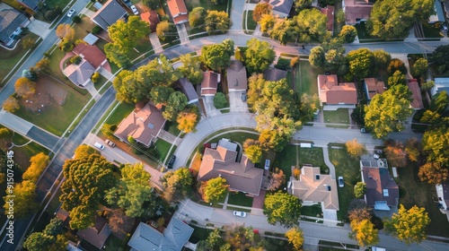 This image features an aerial view showcasing a suburban neighborhood with neatly arranged houses, lush green trees, and curved roads creating an organized urban layout.