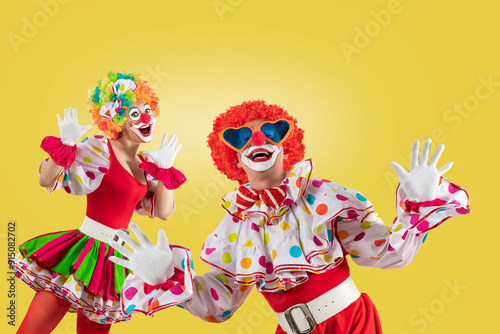 Funny clowns, nan and woman entertainers dressed as a colorful Joker in a suit and wig, with clown whiteface makeup photo