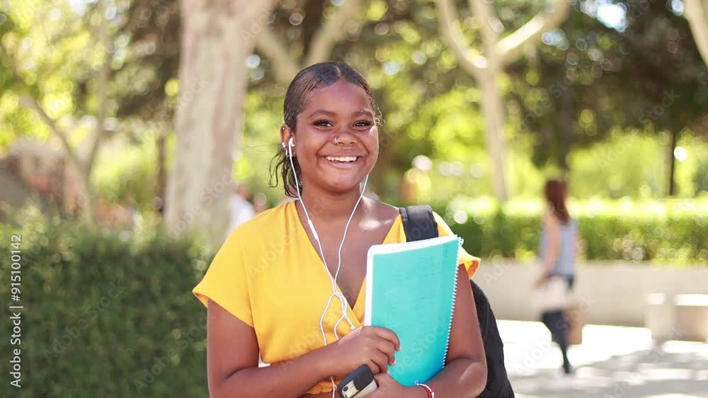 Video of a smiling Hispanic young woman student wearing headphones, looking at the camera as the shot zooms out to reveal a tree-lined urban background
Video of a smiling Hispanic young woman student wearing headphones, looking at the camera as the shot zooms out to reveal a tree-lined urban background