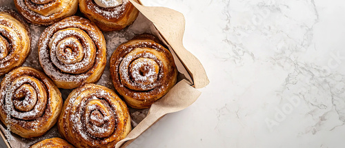 Cinnamon roll or cinnabon in paper box top view Homemade sweet traditional dessert buns with white cream sauce  photo