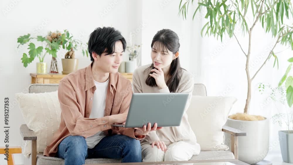 不動産サイトや旅行サイトを見るカップル 不動産サイトや旅行サイトを見るカップル