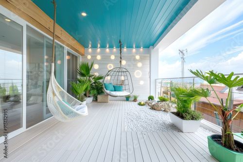 A large terrace with light-colored wooden flooring, decorated with green plants and flowers on the side of the wall