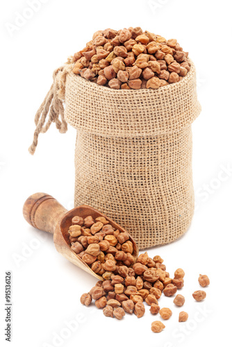 Close-up of Organic Black Chickpeas (Cicer arietinum) or Kala Chana, in a jute bag and on a scoop, Isolated on a white background. photo