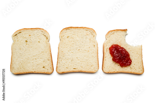 Φωτογραφία Slices of white bread with strawberry jam and bitten on white background, top view
