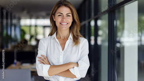 Free Download A portrait of an attractive female business professional standing in her modern office, smiling and looking at the camera.  - GFXLoad