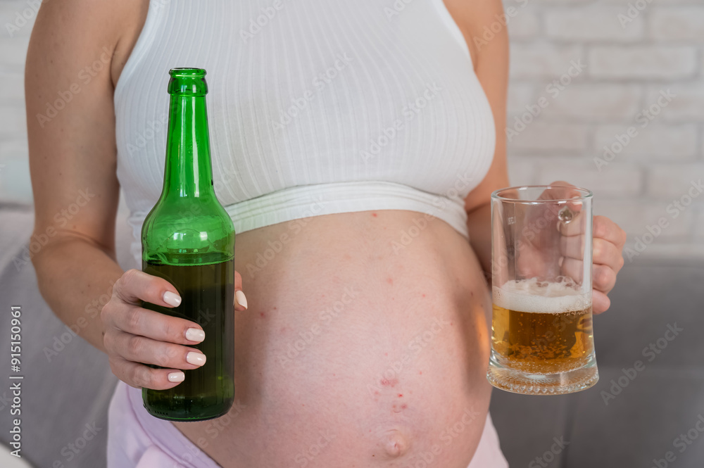 Pregnant woman holding glass and bottle of beer. Pregnant woman holding glass and bottle of beer.