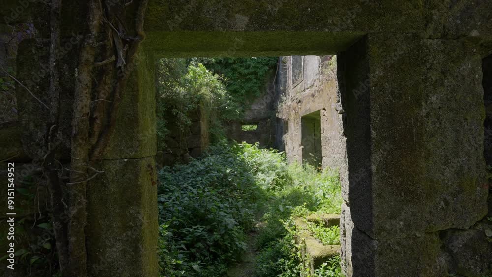 View through a stone doorway leading to an overgrown interior courtyard at Convento de São Francisco do Monte, Viana do Castelo Portugal View through a stone doorway leading to an overgrown interior courtyard at Convento de São Francisco do Monte, Viana do Castelo Portugal