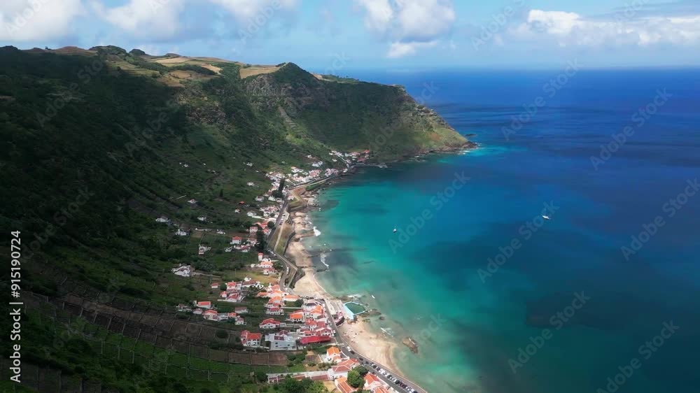 Praia de São Lourenço beach and houses by coastal hills in Azores, aerial pan Praia de São Lourenço beach and houses by coastal hills in Azores, aerial pan