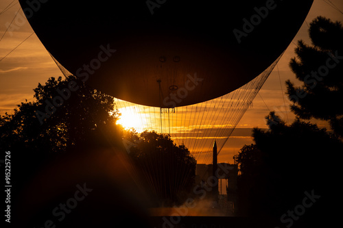 Vasque olympique en gros plan et contre-jour sur fond de soleil couchant avec l'Obélisque en fond photo