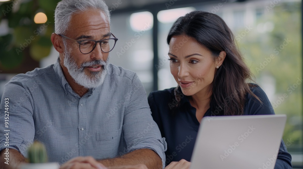 Fototapeta premium a man and woman looking at a laptop